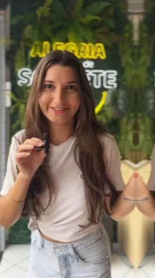 Clara com microfone de lapela gravando em uma sorveteria