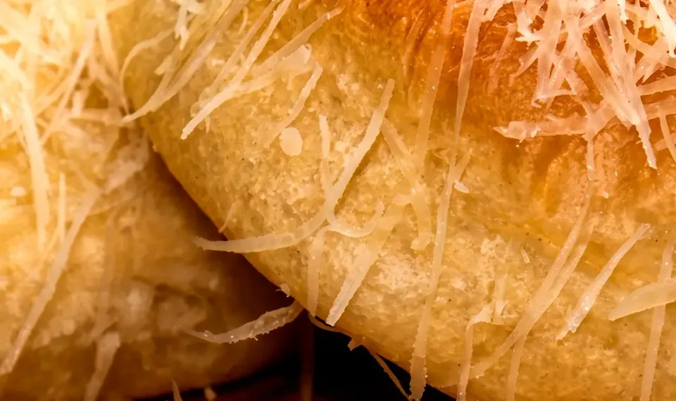 Pão delícia coberto com queijo ralado