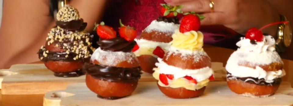 Sonhos gourmet com chantilly, morangos, chocolate e amendoim